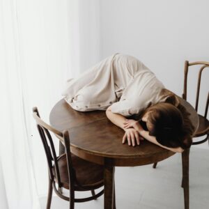 Schemat samopoświęcenia - kiedy troska o innych staje się rezygnacją z siebie 1 Kobieta leżąca na stole, zmęczenie emocjonalne i przeciążenie związane ze schematem samopoświęcenia